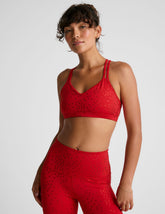 red bra top with a soft v neckline, double crossover straps and a shimmering heart pattern.